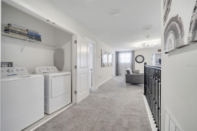 laundry room with washing machine and clothes dryer and light colored carpet