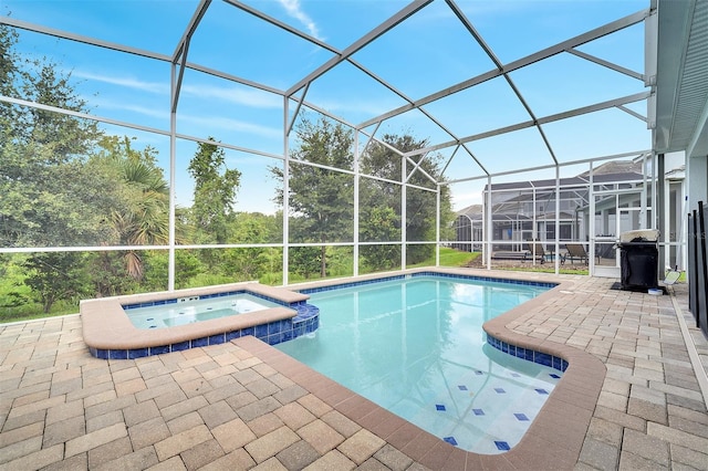 view of pool with an in ground hot tub, a lanai, and a patio area