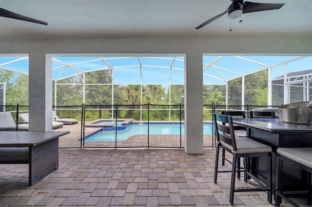 view of pool featuring an in ground hot tub, glass enclosure, ceiling fan, and a patio area