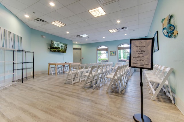 dining space with light wood-type flooring and a paneled ceiling