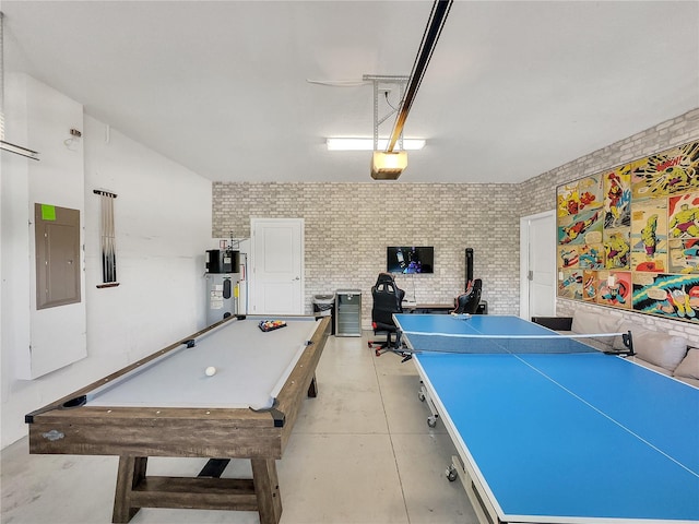 playroom with pool table, electric panel, brick wall, and water heater