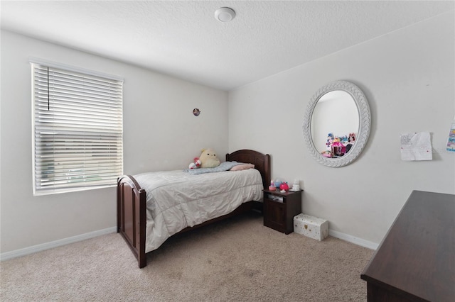 bedroom featuring light carpet and a textured ceiling