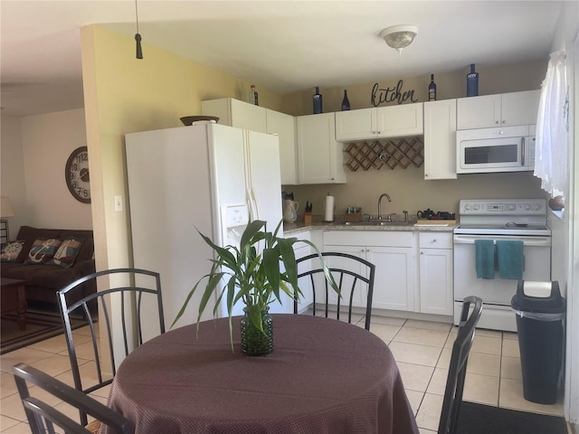 kitchen with sink, white cabinets, light tile patterned flooring, and white appliances