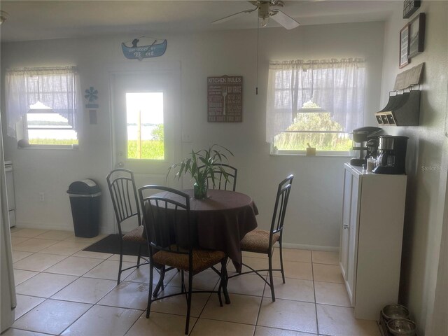 tiled dining space with ceiling fan and a healthy amount of sunlight