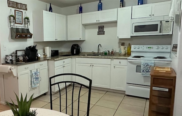 kitchen with white cabinets, white appliances, sink, and light tile patterned floors