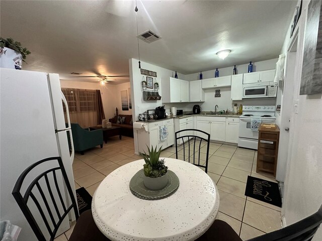 kitchen with white cabinetry, white appliances, sink, and light tile patterned floors