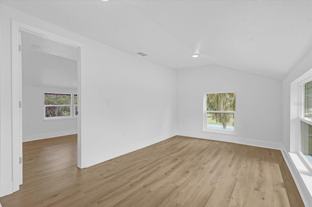 spare room featuring vaulted ceiling and light wood-type flooring