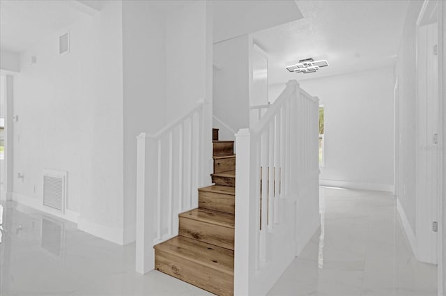 stairs featuring a textured ceiling and hardwood / wood-style flooring