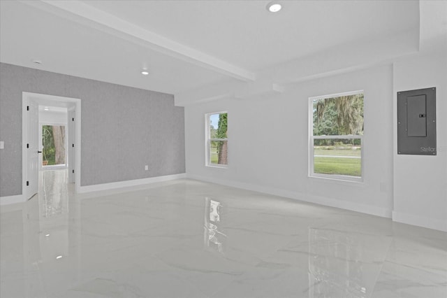 spare room featuring a healthy amount of sunlight, beamed ceiling, and electric panel