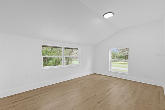 spare room with light hardwood / wood-style floors and lofted ceiling