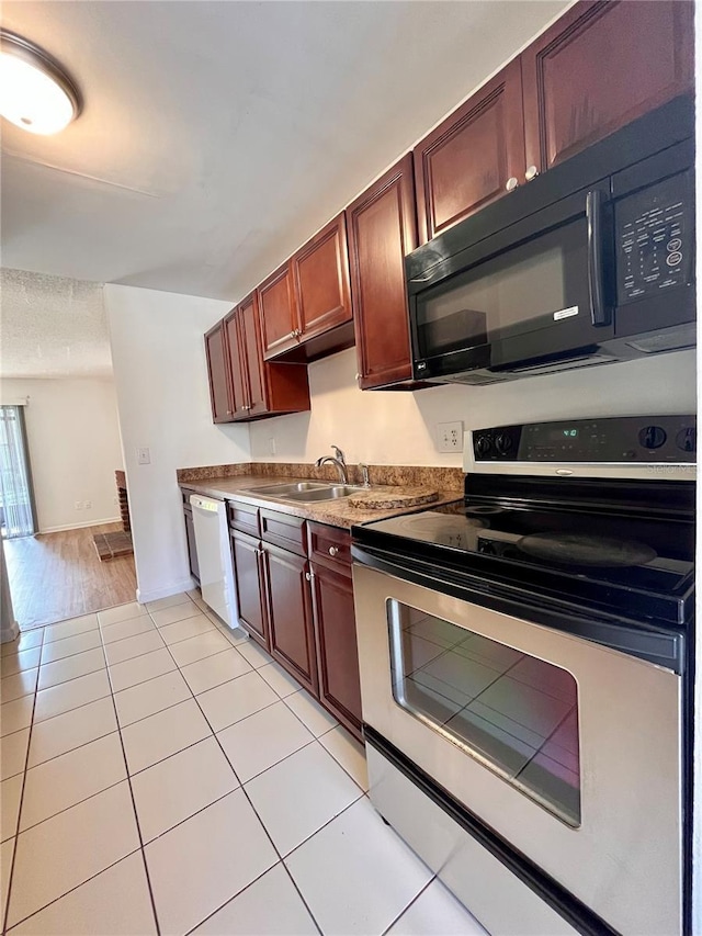 kitchen with light tile patterned floors, dishwasher, stainless steel range with electric stovetop, a sink, and black microwave