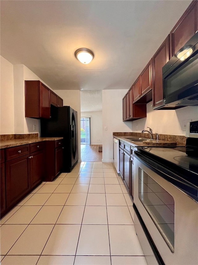 kitchen with black appliances, sink, and light tile patterned floors