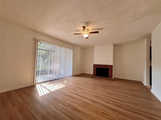 unfurnished living room featuring a textured ceiling, a fireplace, ceiling fan, and hardwood / wood-style flooring