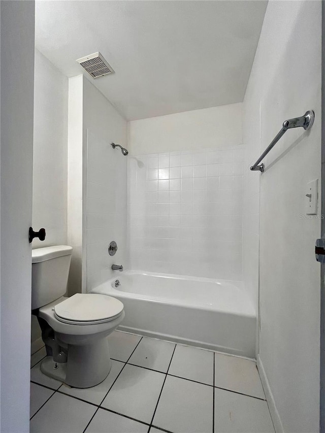 bathroom featuring tiled shower / bath, toilet, and tile patterned floors