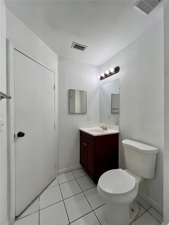 bathroom with tile patterned floors, vanity, visible vents, and toilet