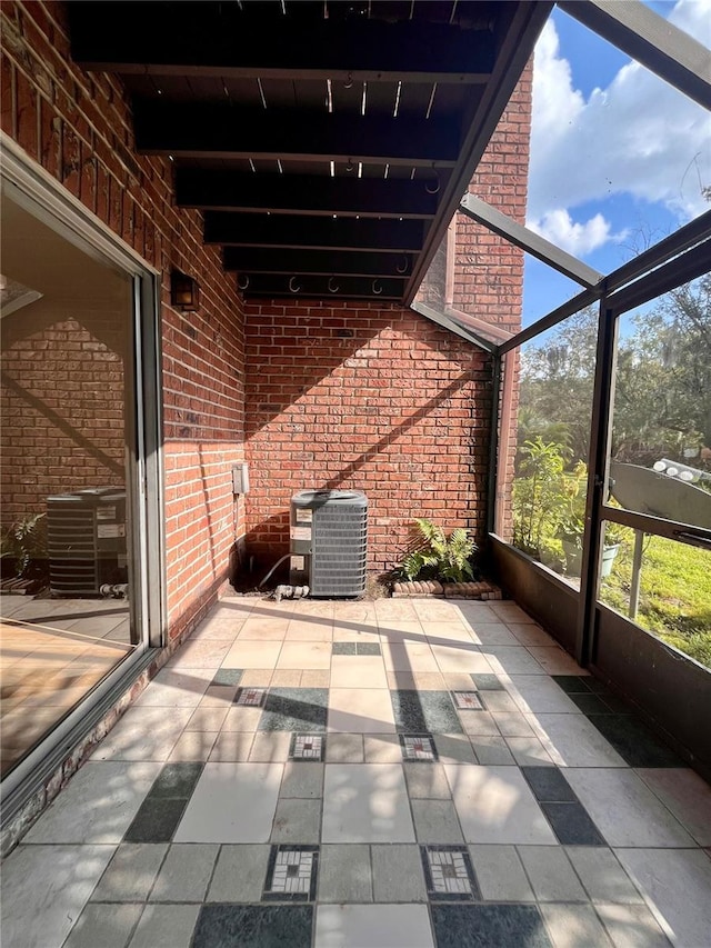 unfurnished sunroom featuring beamed ceiling