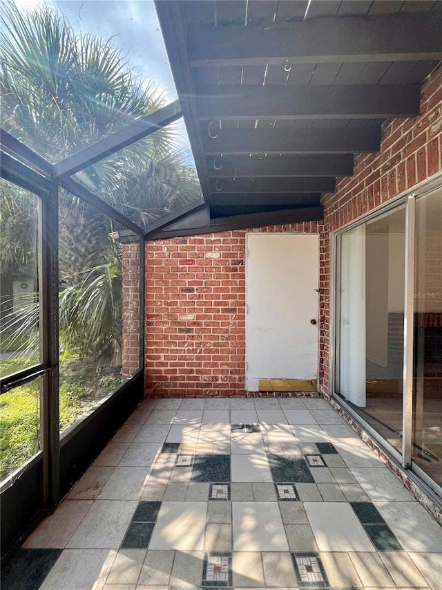 unfurnished sunroom with beam ceiling