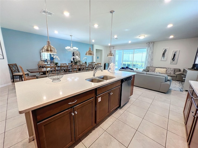 kitchen with a kitchen island with sink, sink, a notable chandelier, decorative light fixtures, and stainless steel dishwasher