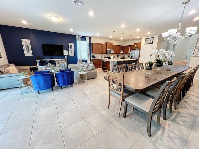 tiled dining room with an inviting chandelier