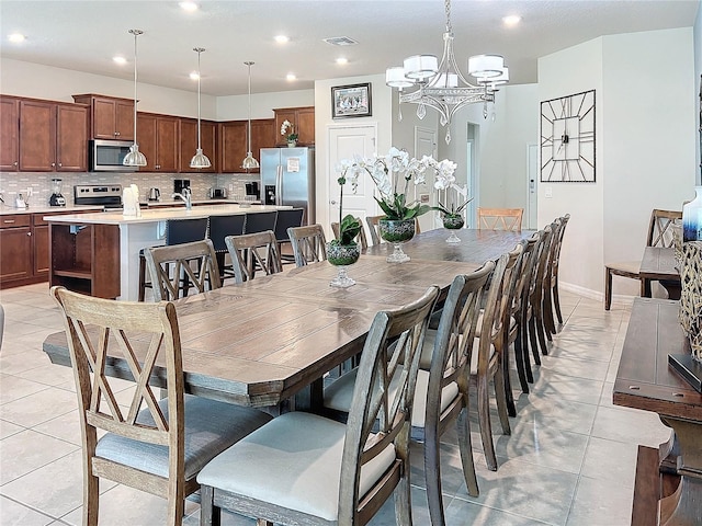 dining room featuring an inviting chandelier, sink, and light tile patterned floors