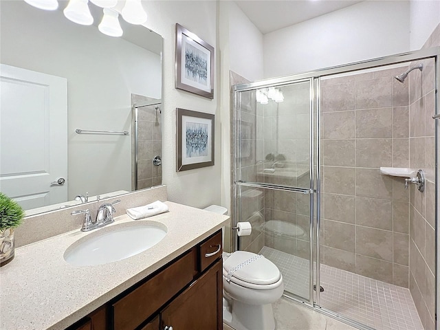 bathroom featuring toilet, a shower with shower door, and vanity