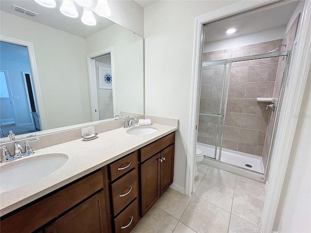 bathroom featuring vanity, toilet, a shower with shower door, and tile patterned flooring