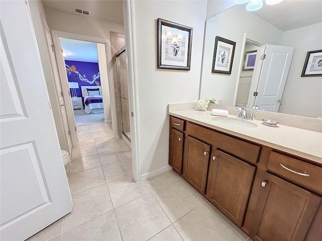 bathroom featuring vanity, toilet, tile patterned floors, and a shower with door