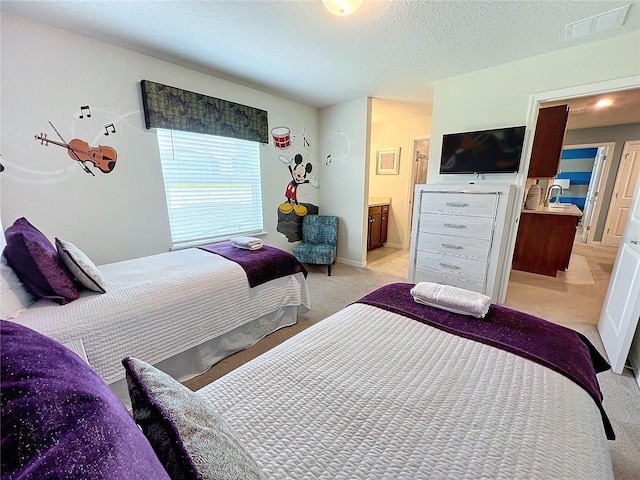 bedroom with light carpet, a textured ceiling, ensuite bath, and sink