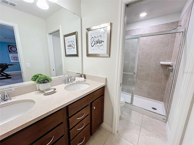 bathroom with vanity, toilet, tile patterned floors, and a shower with shower door