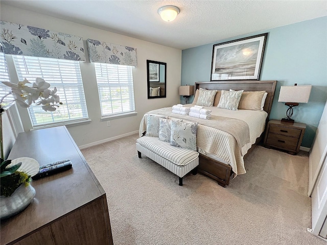 bedroom with a textured ceiling and light colored carpet