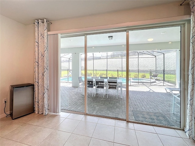 doorway with light tile patterned flooring and a wealth of natural light