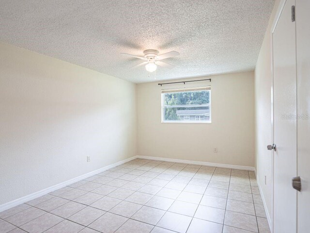 tiled spare room with ceiling fan and a textured ceiling