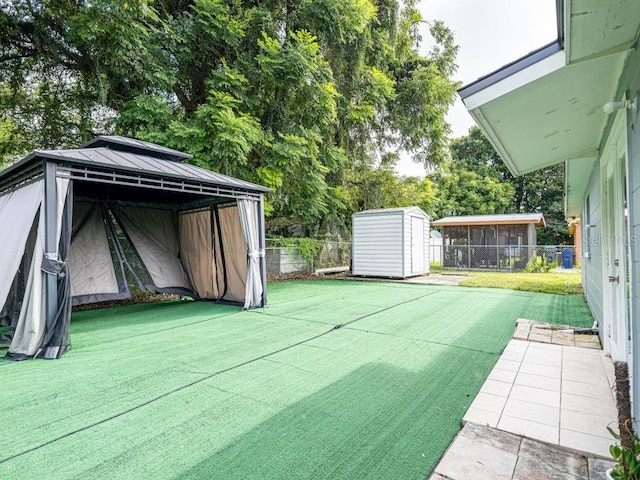 view of yard featuring a storage shed and a patio