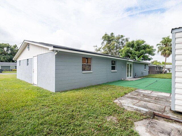 rear view of house with a lawn and a patio area