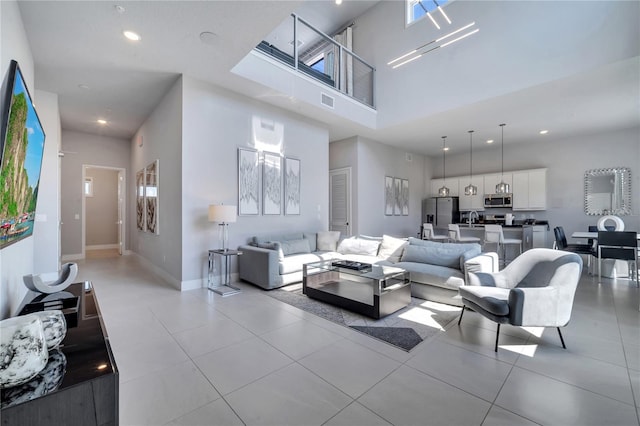 living room with light tile patterned floors and a high ceiling