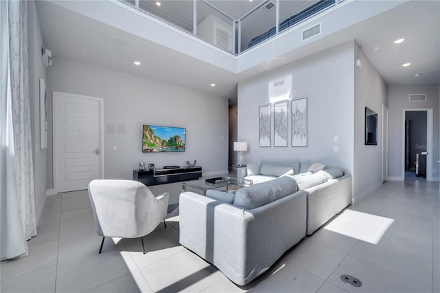 tiled living room featuring a high ceiling