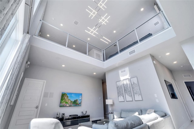 living room featuring a notable chandelier and a towering ceiling