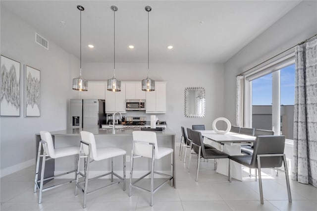 dining room featuring sink and light tile patterned floors