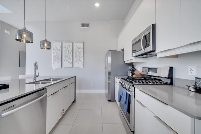 kitchen with appliances with stainless steel finishes, hanging light fixtures, white cabinetry, and sink