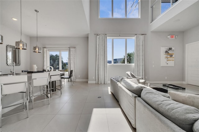 tiled living room with a high ceiling and plenty of natural light