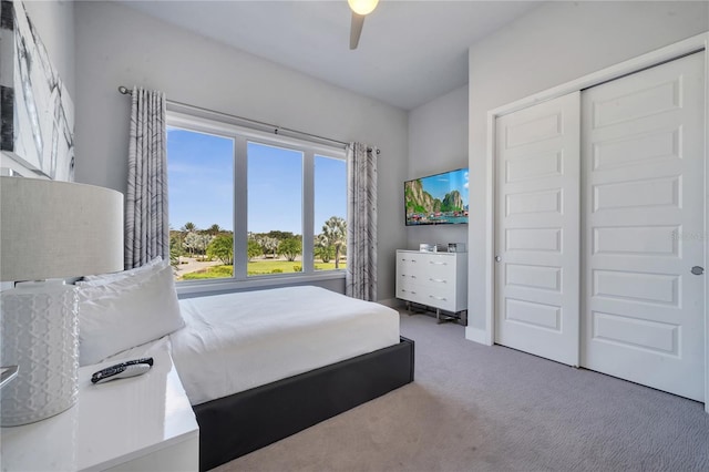 carpeted bedroom featuring ceiling fan and a closet