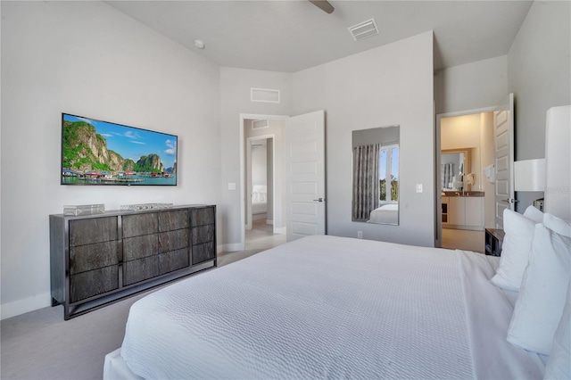 bedroom featuring ensuite bath, light carpet, and ceiling fan