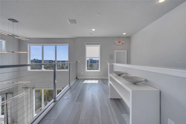 hallway with a textured ceiling and hardwood / wood-style flooring