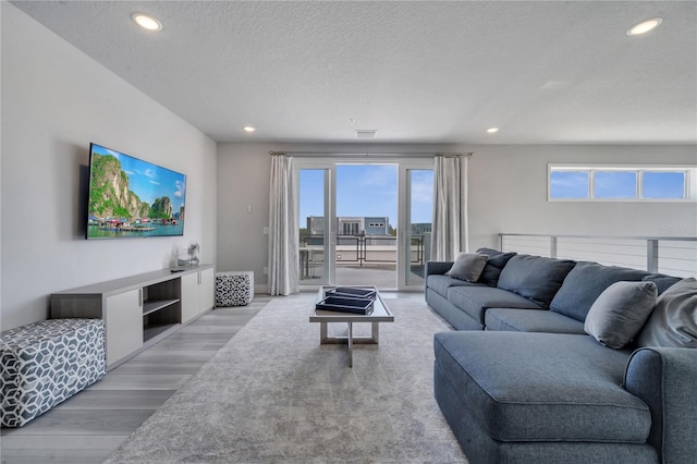 living room with a textured ceiling and light hardwood / wood-style floors