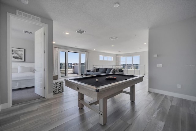 rec room with a textured ceiling, hardwood / wood-style floors, and billiards