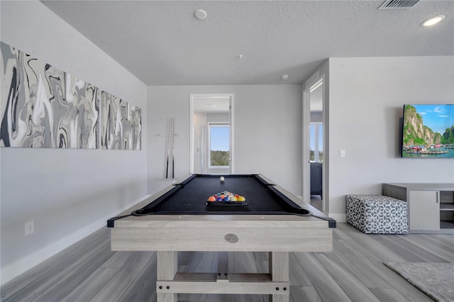 rec room featuring light wood-type flooring, a textured ceiling, and billiards