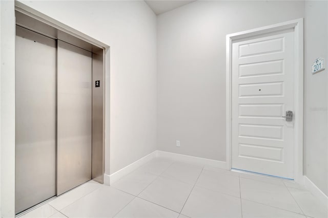 doorway to outside featuring light tile patterned floors and elevator