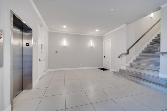 entrance foyer featuring crown molding, light tile patterned floors, and elevator