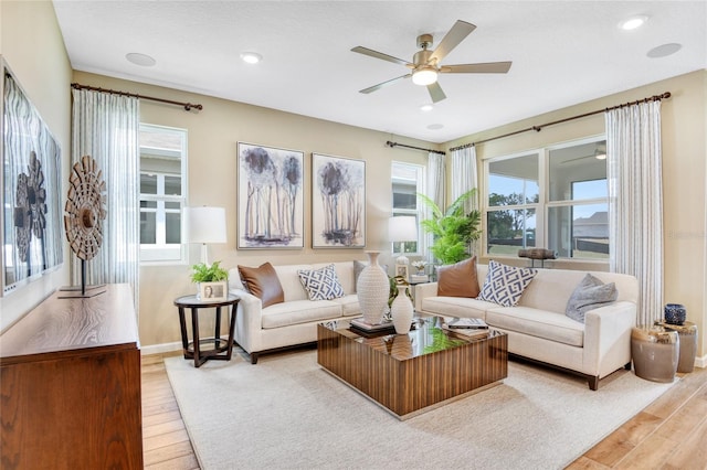 living room with light hardwood / wood-style floors and ceiling fan