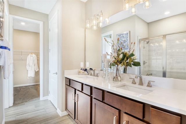 bathroom with wood-type flooring, vanity, and a shower with door